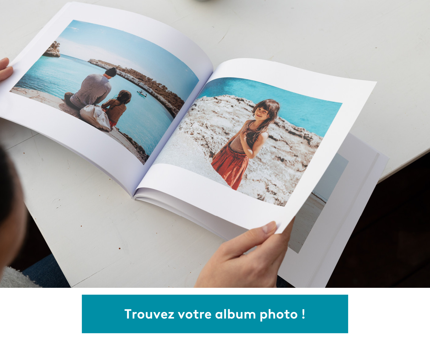 Une femme (hors champ) tient un album photo ouvert, rempli d’images des vacances en famille.