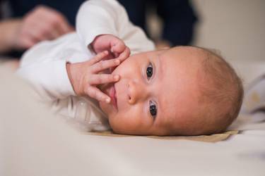 Bébé en petite veste blanche sur la table à langer