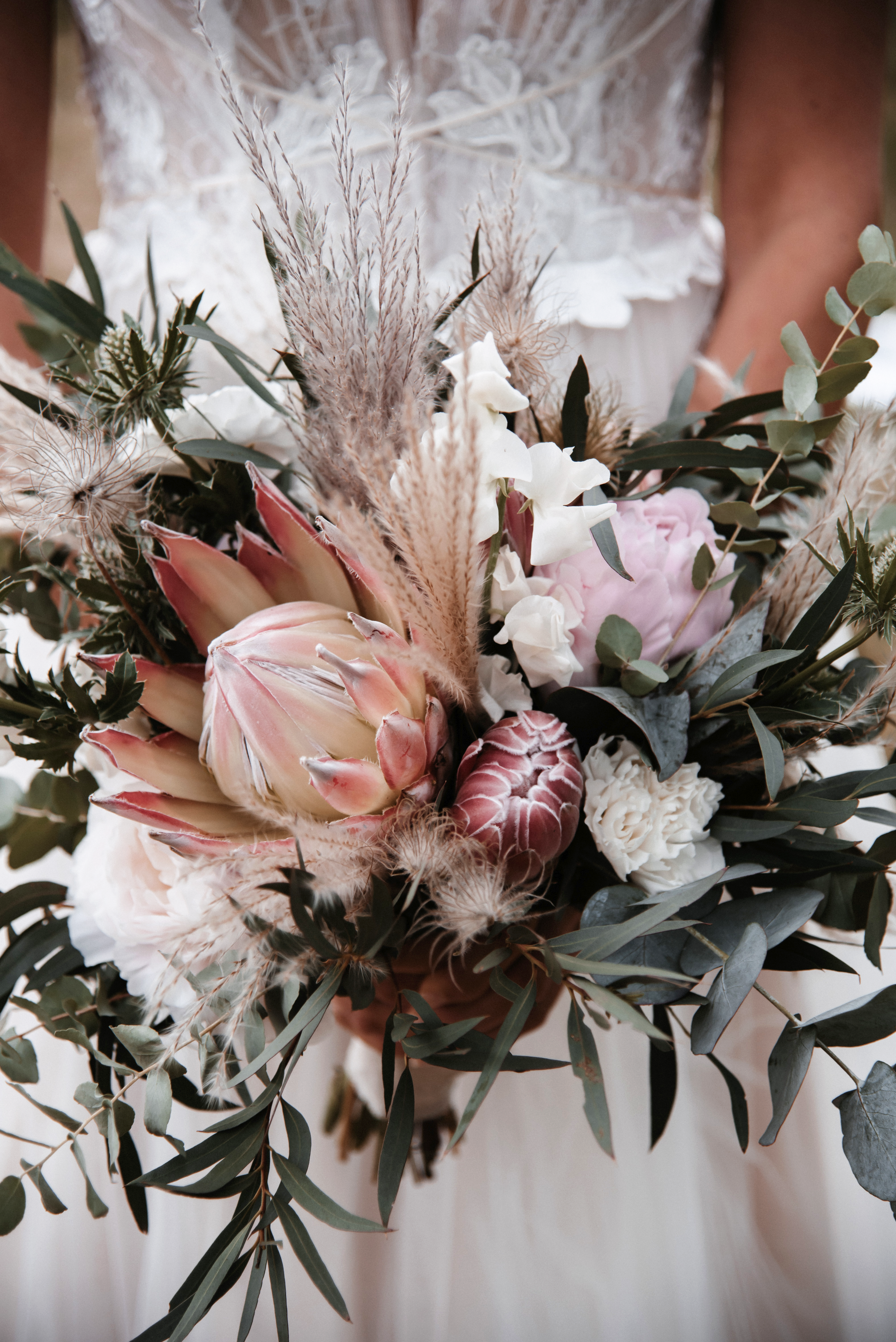 Pivoine, chardon, eucalyptus et herbe de pampa ornent ce superbe bouquet de mariage