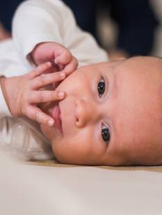 Bébé en petite veste blanche sur la table à langer