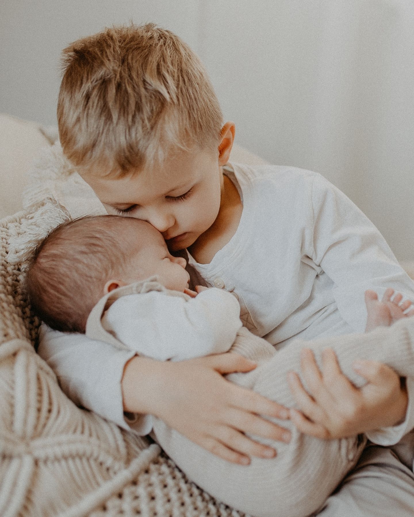 Bébé blotti dans les bras de son grand frère.