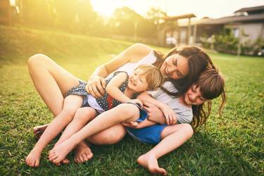 Shot of a mother bonding with her two adorable little children outdoors