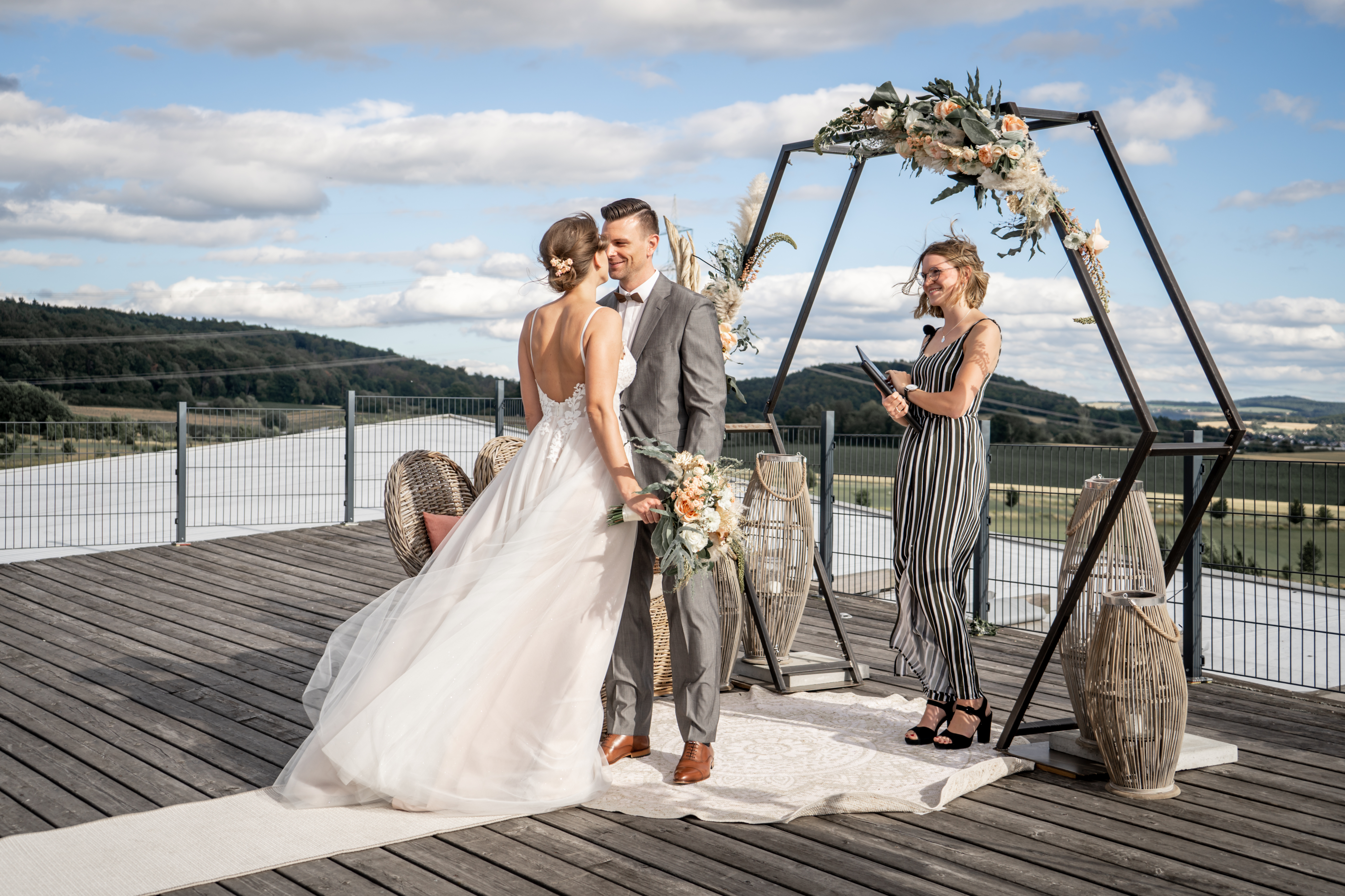 Couple se mariant en plein air floral bohème arche hexagonal